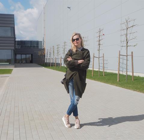 Architect Ignė Grigaliūnaitė from architects Kita kryptis stands in the yard in front of the building she designed. 